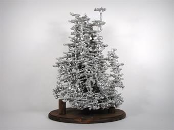 A very large aluminum fire ant colony cast displayed on a wood base.
